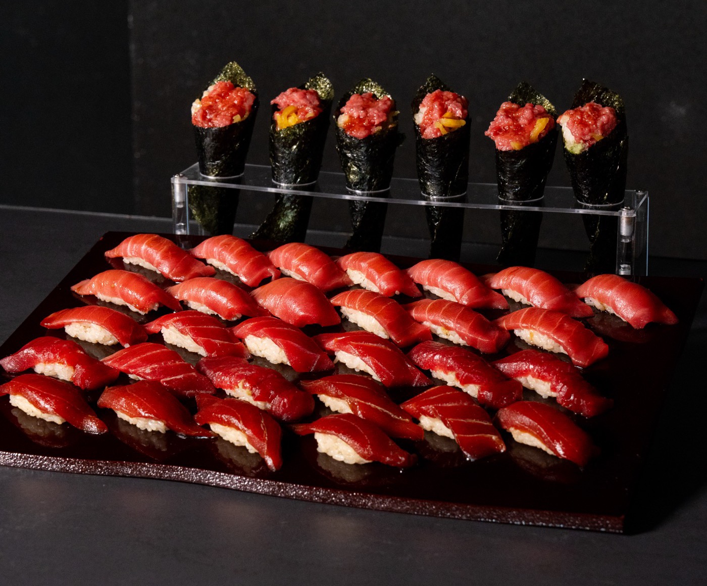 The full spread — thirty tuna nigiri on a lacquer board, six hand rolls standing behind
